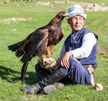 Issyk Kul, Kırgızistan - 28 Mayıs 2017 - Kartal avcısı kartalını kolunda tutuyor