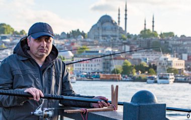 İstanbul, Türkiye - 30 Nisan 2016 - Adam iskelede balık tutuyor