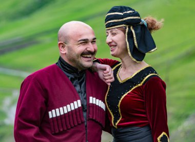 Mestia, Georgia - 11 Haziran 2016 - Geleneksel ortaçağ kıyafetleri içindeki kadın ve erkek aynı kahkahayı paylaşıyor