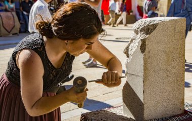 Penedono, Portekiz - 1 Temmuz 2017 - Kadın her yıl düzenlenen Ortaçağ Fuarı 'nda yeni heykel oyuyor