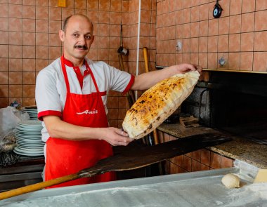 Antalyna, Türkiye - 4 Ağustos 2016 - Baker fırından yeni çıkmış düz ekmeklerle hava atıyor
