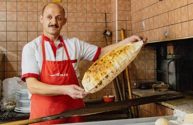 Antalyna, Türkiye - 4 Ağustos 2016 - Baker fırından yeni çıkmış düz ekmeklerle hava atıyor