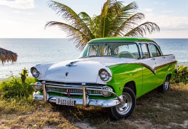 Yeşil beyaz Ford Fairlane plaja park etmiş.