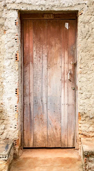 Noszone brązowe drzwi na zniszczonej ścianie z żółtej cegły. Znak na drzwiach wskazuje, że spis kubański jest kompletny. — Zdjęcie stockowe