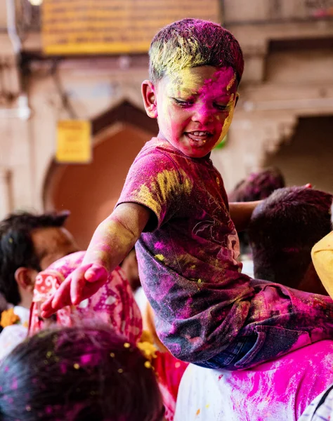 Boy sits on father s shoulders while dumping paint on nearby head during Holi Festival in India — Stock Photo, Image