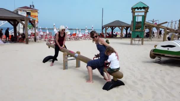 Tel Aviv, Izrael - 2019-04-27 - Beach Teetter Totter 2 felnőttel és 1 gyerekkel — Stock videók