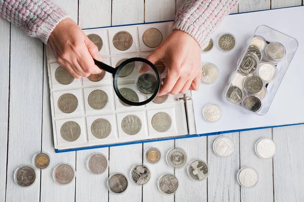 Vrouw Kijkt Naar Munten Door Middel Van Een Vergrootglas Glas — Stockfoto