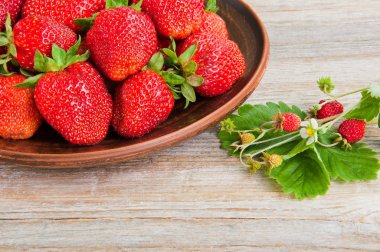 Ahşap masada bir plaka üzerinde taze çilek
