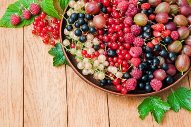 Ahşap bir masada bir tabak üzerinde taze organik çilek