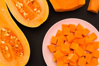 Armut şekilli balkabağı ikiye bölünmüş ve kabak parçalarını yemek için bir tabakta dilimlenmiş.