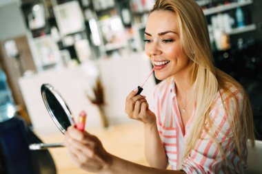 Genç güzel kadın olun küçük ayna güzellik salonunda kullanarak uygulama