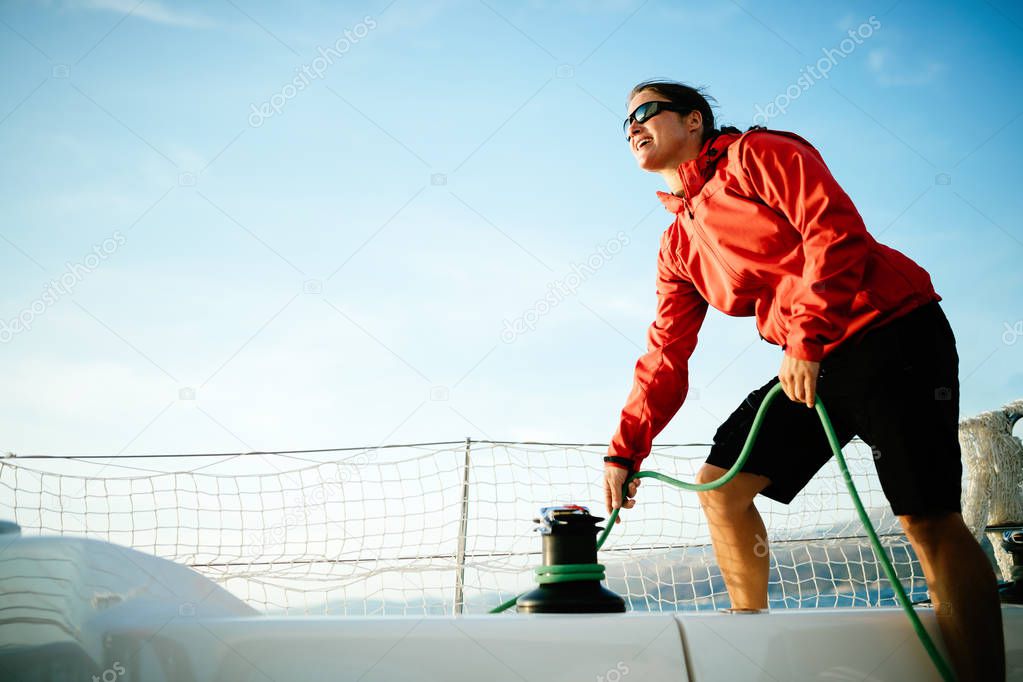 Attractive strong woman sailing with her sail boat