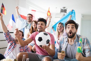 Arkadaşlar televizyonda futbol maç izlerken neşeli ve mutlu grup.