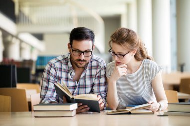 Genç bir kadın ve erkek sınava çalışıyor. Halk, öğrenim, eğitim ve okul kavramı