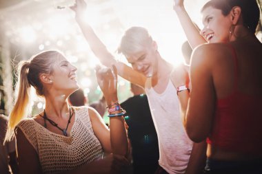 Mutlu genç arkadaşlar müzik festivalinde eğleniyor.