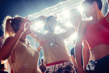 Mutlu genç arkadaşlar müzik festivalinde eğleniyor.