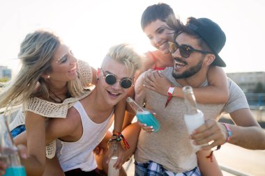 Mutlu genç arkadaşlar müzik festivalinde eğleniyor.