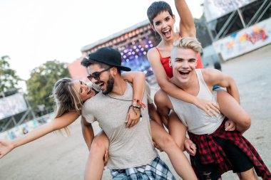 Mutlu genç arkadaşlar müzik festivalinde eğleniyor.