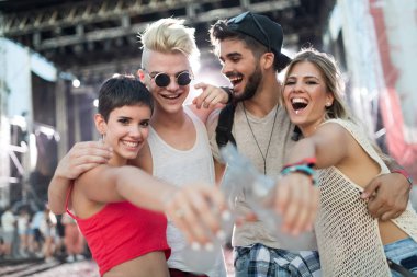 Mutlu genç arkadaşlar müzik festivalinde eğleniyor.