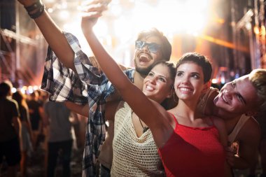 Mutlu genç arkadaşlar müzik festivalinde eğleniyor.