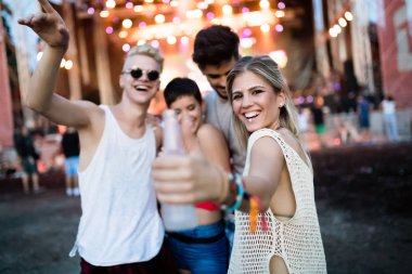 Mutlu genç arkadaşlar müzik festivalinde eğleniyor.