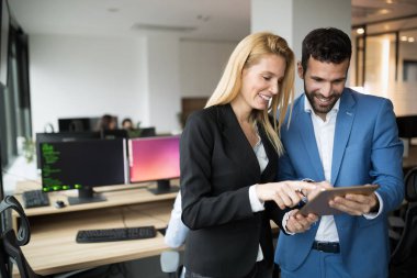 İş adamları ofiste dijital tablet kullanırken tartışıyor