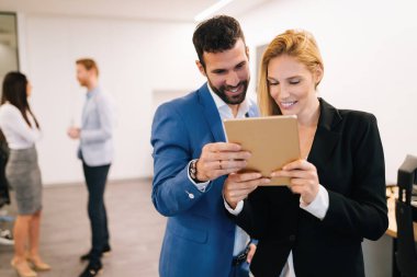 İş adamları ofiste dijital tablet kullanırken tartışıyor