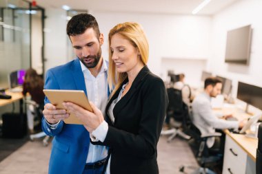 İş adamları ofiste dijital tablet kullanırken tartışıyor