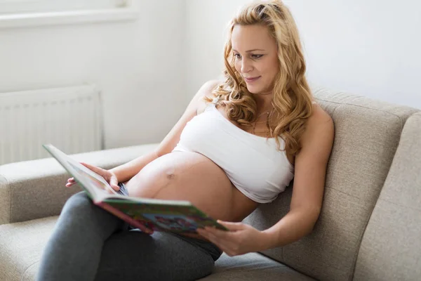 Zwangere Vrouw Thuis Rusten Lezen Van Boek Bank — Stockfoto