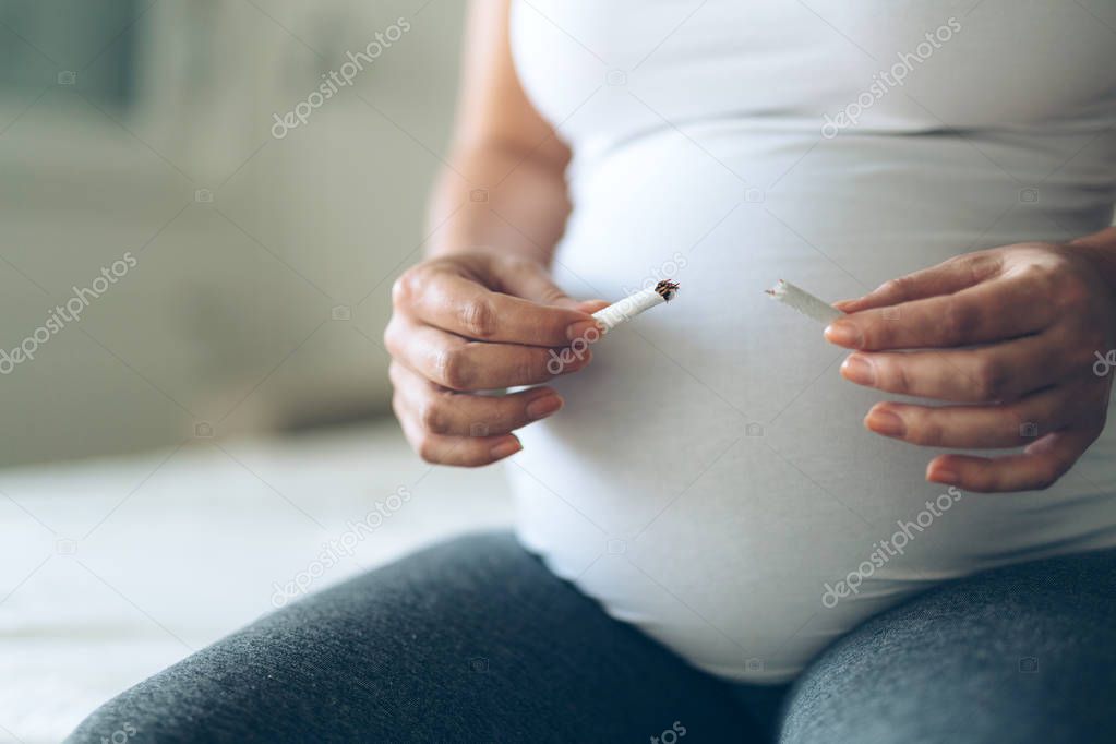 Health minded pregnant woman breaks her last cigarette