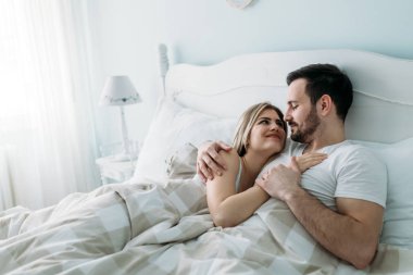 Yatak odasında genç çekici sevgi dolu çift portresi