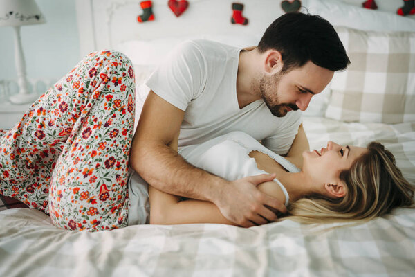 Портрет молодой привлекательной влюбленной пары в спальне
