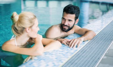 Mutlu çekici çift rahatlatıcı spa yüzme havuzunda