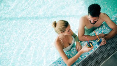 Mutlu çekici çift rahatlatıcı spa yüzme havuzunda