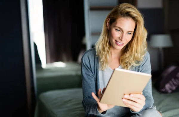 Portrait of attractive woman in hotel room using tablet