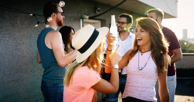 Bir grup arkadaş çatıdaki partide eğleniyor..