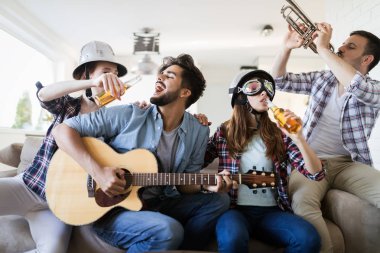 Birlikte parti ve aletleri oynamak neşeli genç arkadaşlar