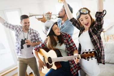 Neşeli mutlu grup arkadaşıyla birlikte eğleniyor aletleri oynamak ve içme