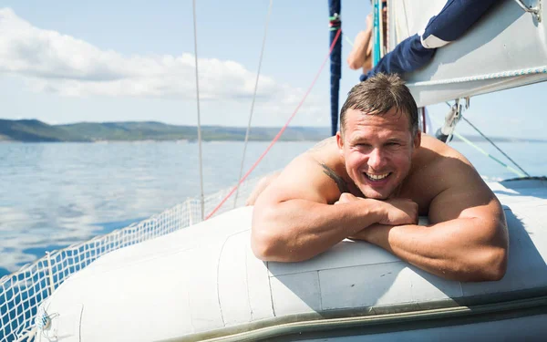 ハンサムな笑みを浮かべて男彼のボートで日光浴をリラックス — ストック写真