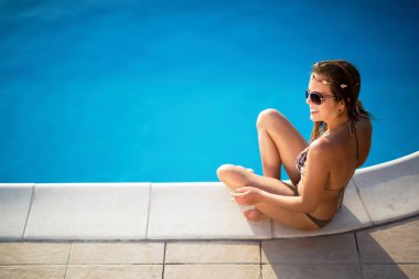 Zarif seksi kadın güneş tabaklanmış ince ve düzgün vücut üzerinde bikini Yüzme Havuzu poz