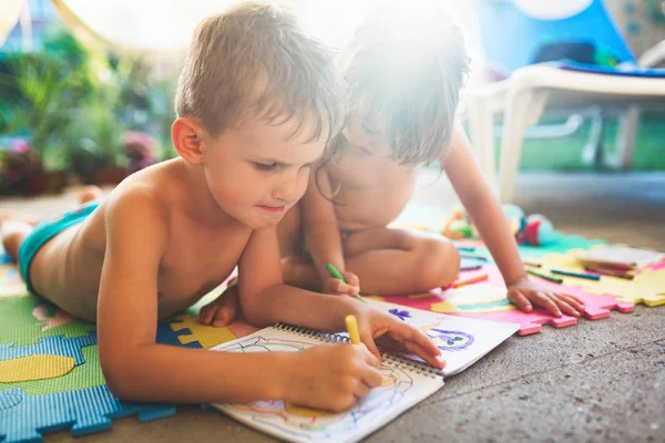 Niño y niña dibujando con lápices de colores — Foto de Stock