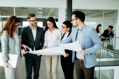 Bir grup mimar ve iş adamı birlikte çalışıyor ve beyin fırtınası yapıyorlar.