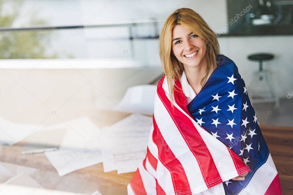 Beautiful young woman wrapped in American flag