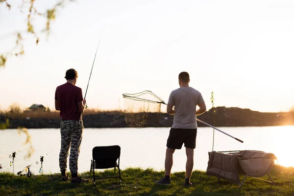 Hombres Jóvenes Pescando Lago Atardecer Disfrutando Hobby Recreación — Foto de Stock