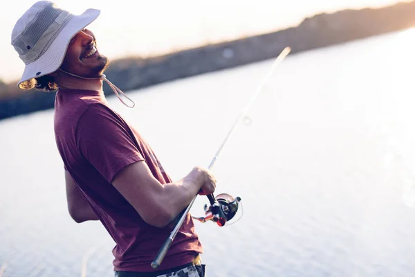 Jovem pescando na lagoa e desfrutando de hobby — Fotografia de Stock