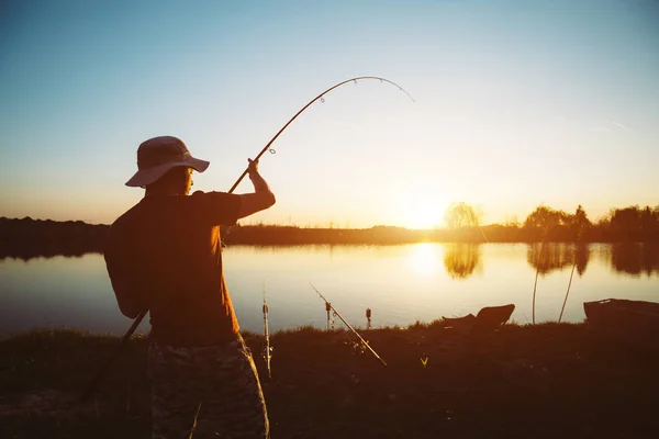 Giovane uomo pesca allo stagno e godendo hobby — Foto Stock