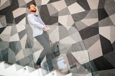 Eldeki güncel kalmak için tablet ve telefon sürekli sahip iş adamı