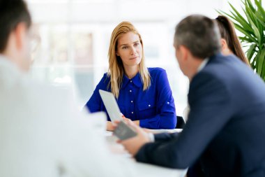 İş adamları ofiste yeni fikirler üzerinden işbirliği yapıyor ve konuşuyorlar.