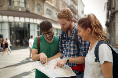Harita gezi şehirde tutan genç mutlu turist