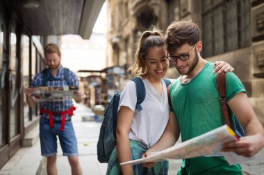 Harita gezi şehirde tutan genç mutlu turist
